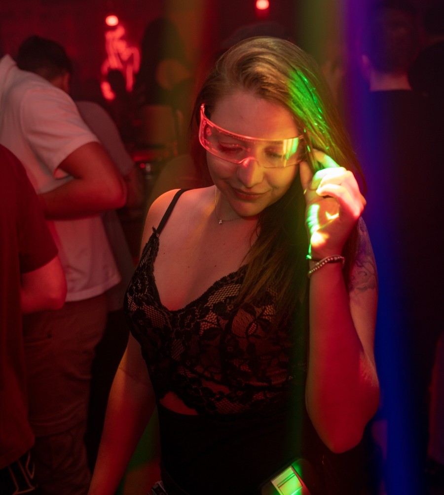 Girl in a nightclub adjusting her glasses